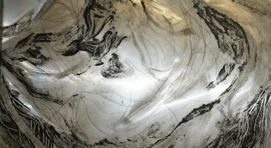 Textura metálica con trazos negros y finas líneas, evocando un grabado en carborundum.