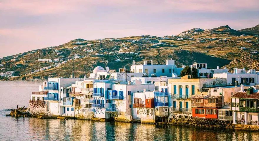 Charming waterfront houses with blue shutters, a classic view of places in Greece to visit.