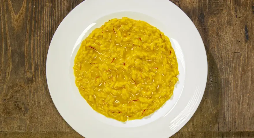 Un cremoso risotto alla milanese, con i suoi fili rossi di zafferano che promettono un sapore autentico.