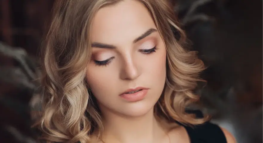 Delikatny makijaż na święta podkreśla urodę kobiety z blond włosami.