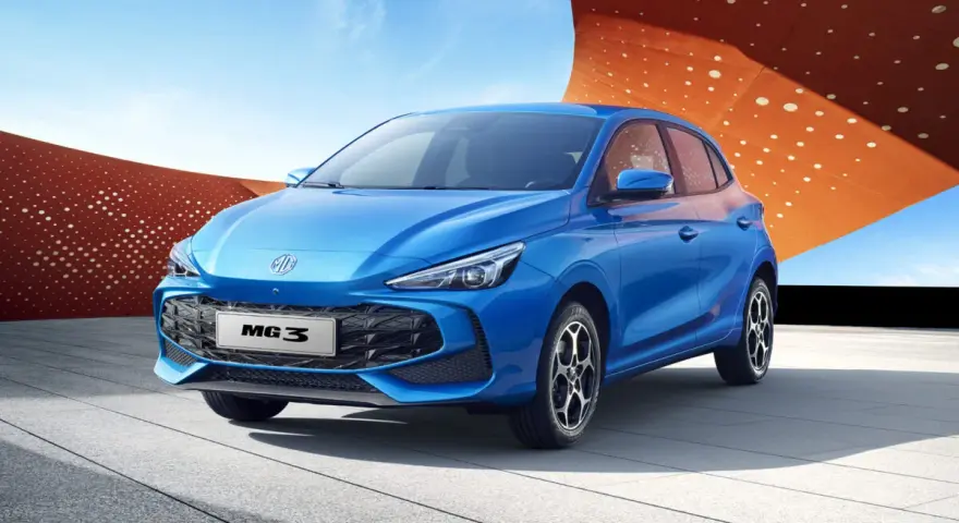 Niebieski samochód MG3 Hybrid+ na tle nowoczesnej architektury.