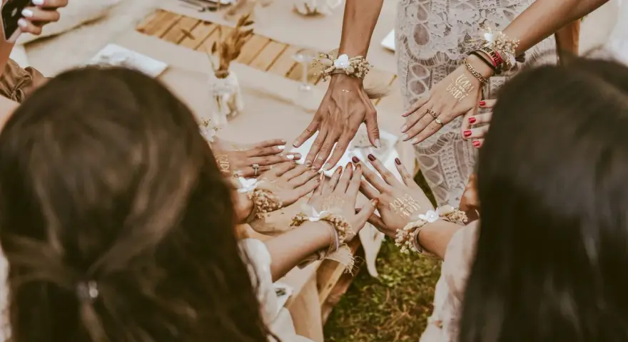 Dłonie ozdobione tatuażami "Team Bride" i bransoletkami z kwiatów. Wspaniałe panieńskie pomysły na celebrację!