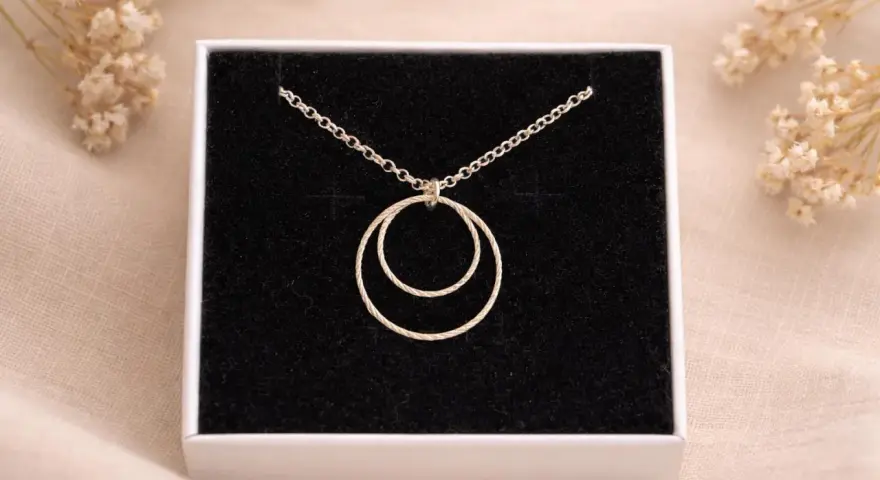 Collana con due anelli intrecciati, simbolo di legame eterno e unione.