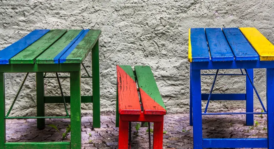 Muebles coloridos, como mesas y bancos, hechos con **objetos reciclados fáciles de hacer**.