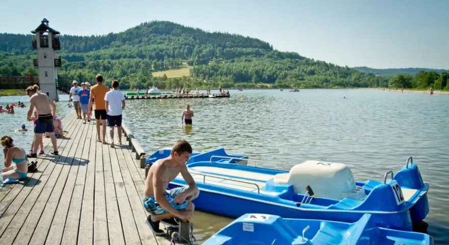 Letni dzień nad jeziorem, popularne wśród turystów śląskie atrakcje turystyczne. Ludzie odpoczywają na pomoście i w wodzie.