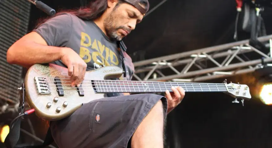 Robert Trujillo z zespołu gra na basie, skupiony na występie.