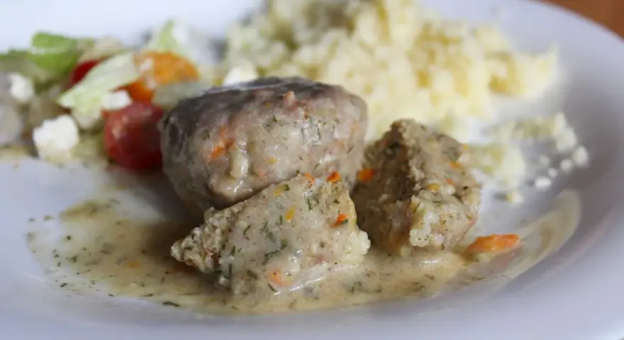 Miękkie pulpety drobiowe w sosie z koperkiem i marchewką, podane z purée ziemniaczanym i sałatką.