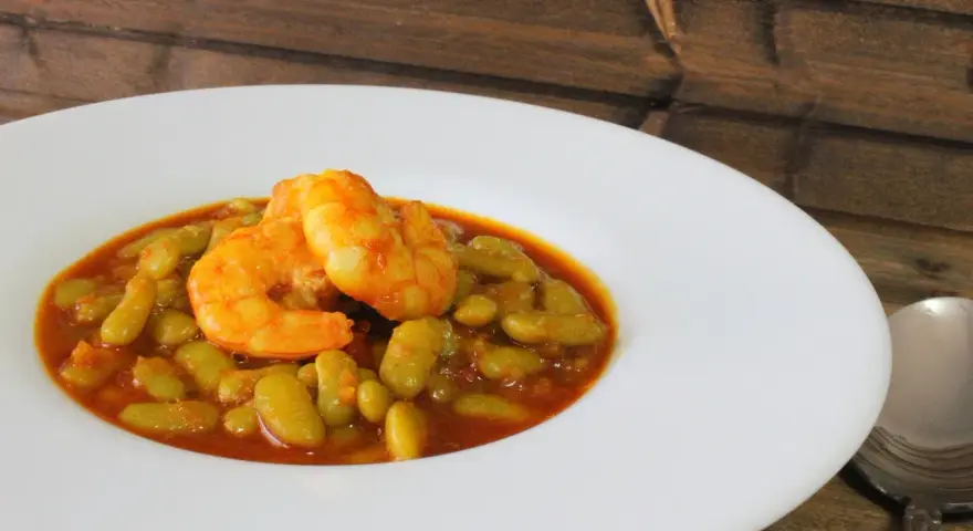 Plato de verdinas con langostinos, un guiso casero lleno de sabor.