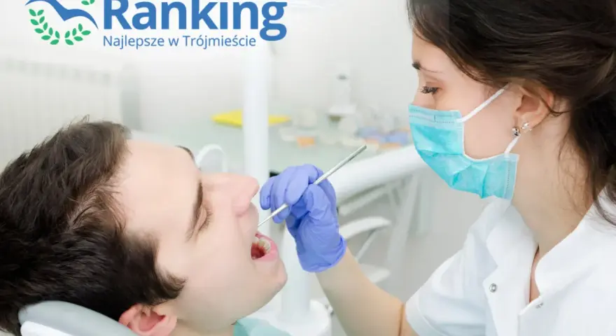 Dentystka w masce bada zęby pacjenta w gabinecie stomatologicznym.