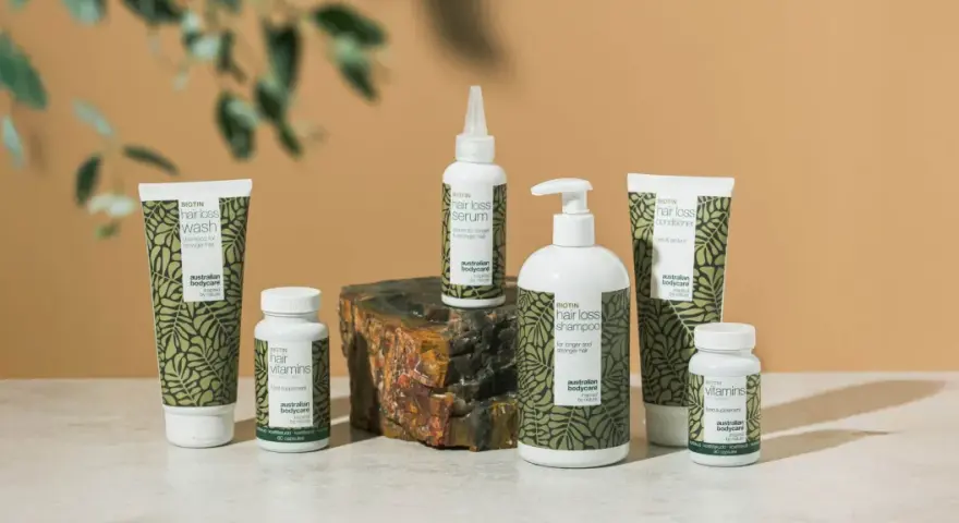 En samling hårvårdsprodukter med biotin, inklusive schampo, balsam, serum och kosttillskott. Biotin mat för starkare hår.