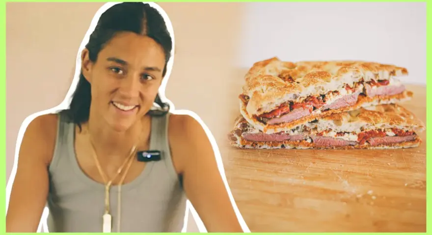 Mujer sonriente junto a un pepito de ternera cortado en dos, mostrando el relleno de carne, queso y pimientos.