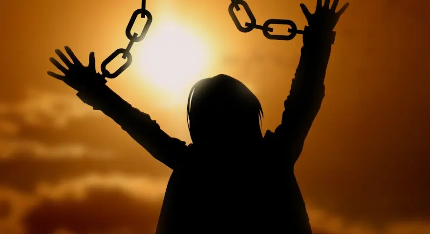 Silhouette einer Person, die sich von Ketten befreit, symbolisiert die Vergebung, wie sie in der Bibel gelehrt wird.