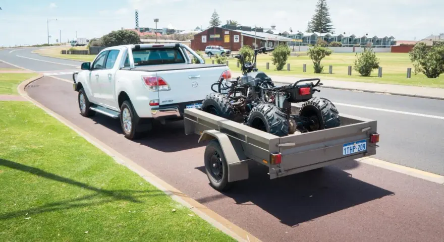 Un quad è trasportato su un rimorchio, parte integrante del veicolo, pronto per l'avventura.