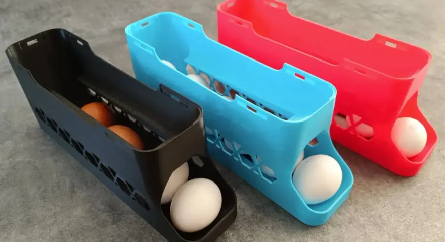 3D printed egg holders in black, blue, and red. See what you can do with a 3d printer: create practical kitchen organizers!