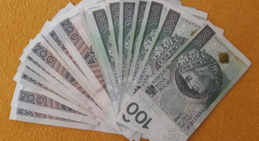 Stos banknotów 100 i 200 zł, gotowy na darowiznę dla dziecka.