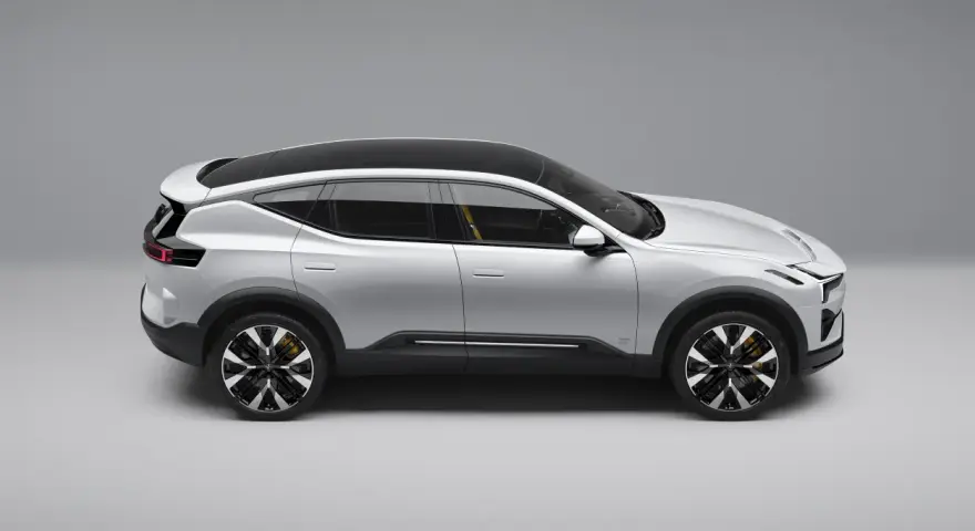 Srebrny SUV Polestar 3 z czarnym dachem i żółtymi zaciskami hamulcowymi, widziany z boku.