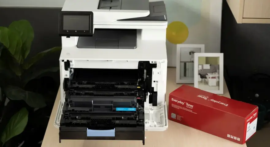Wymiana tonera w drukarce c2000. Obok czerwone pudełko z tonerem Everyday Toner by Xerox.