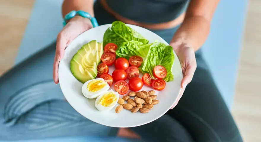 Talerz z awokado, pomidorkami, jajkiem i migdałami – idealny posiłek dla osób stosujących dietę imitującą post.
