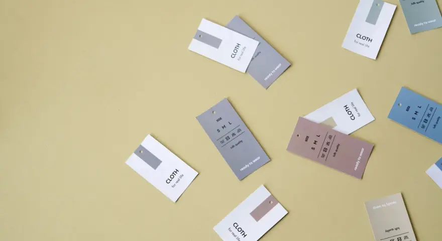 Etykiety odzieżowe z napisem "CLOTH for real life" i symbolami pielęgnacji. Nawet syntetyki mogą być wysokiej jakości.
