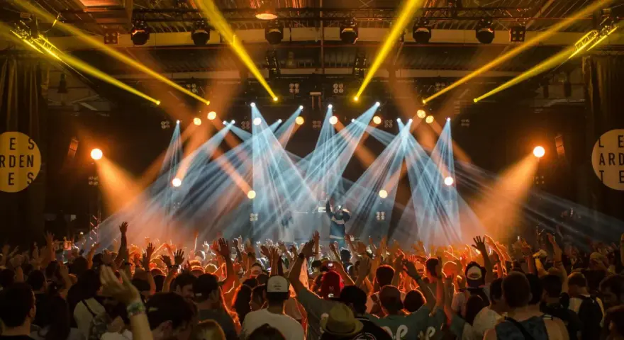 Tłumy na festiwalu muzycznym szaleją pod światłami sceny.