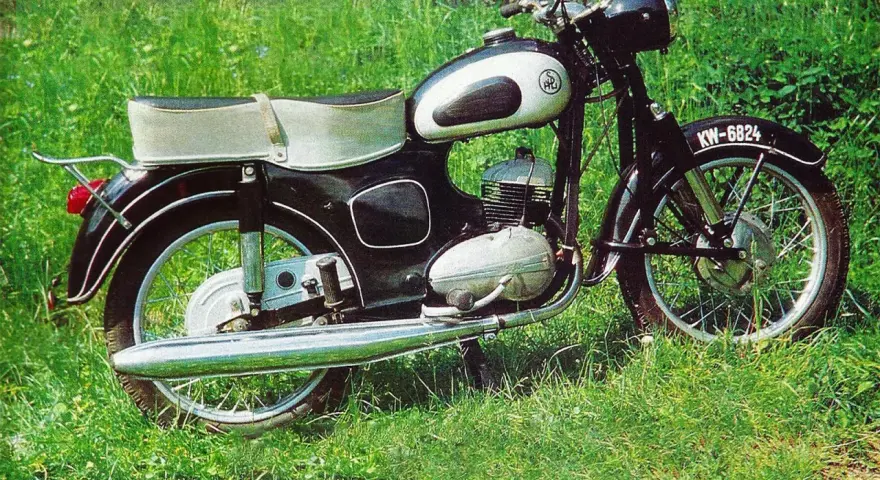 Klasyczny motocykl SHL M11 na tle zielonej trawy. Poznaj jego shl m11 dane techniczne i poczuj ducha minionej epoki.