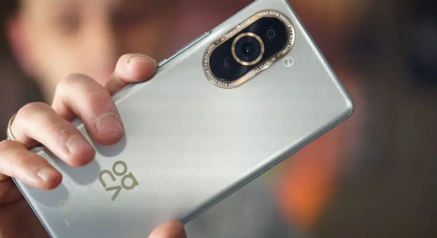 Dłoń trzyma srebrny Huawei Nova 10 Pro, ukazując moduł potrójnego aparatu z 50MP RYYB sensorem.