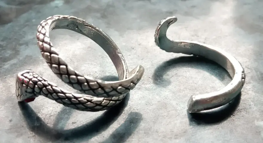Anello a serpente spezzato, con la testa e il corpo da un lato e l'estremità aperta dall'altro. Un'idea su come aggiustare un anello spezzato.