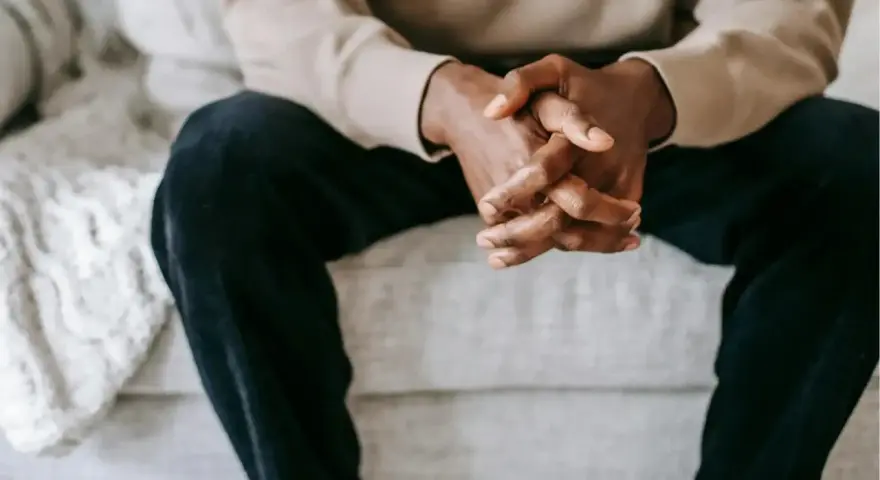 Mains jointes d'un homme, une posture qui peut exprimer le désir, la contemplation ou l'attente.