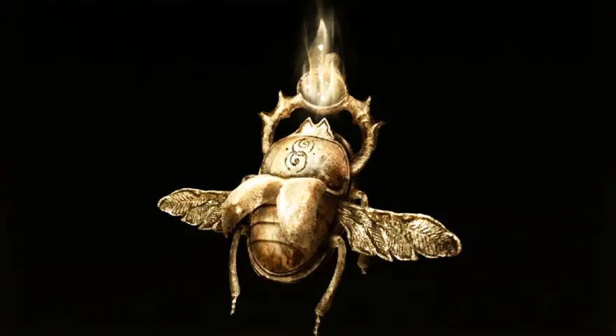 Un escarabajo dorado con alas, símbolo de todos los talismanes legendarios de Elden Ring, brilla con una luz etérea.