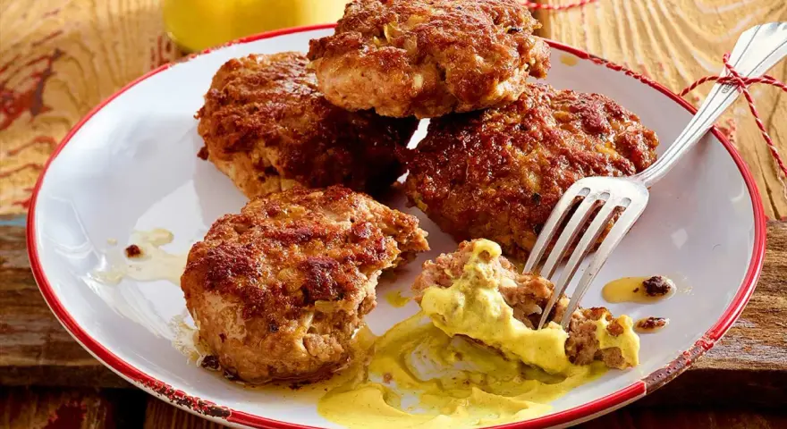 Leckere Frikadellen, goldbraun gebraten, mit Senf auf einem Teller. Ein perfektes Frikadellen Rezept für jeden Anlass.