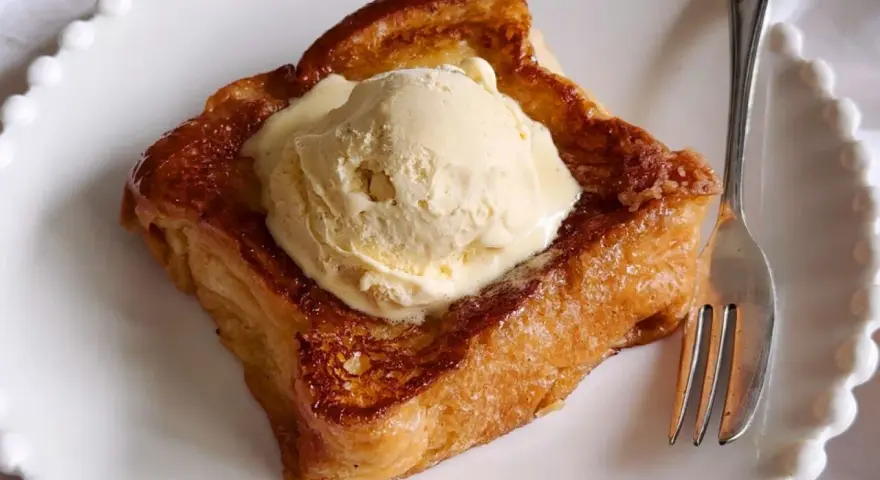 Torrijas con pan brioche, doradas y crujientes, coronadas con una generosa bola de helado de vainilla. Un postre irresistible.