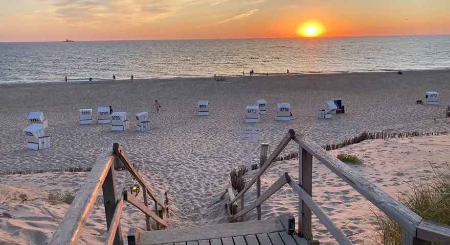 Sonnenuntergang am Strand von Sylt. Strandkörbe warten auf Besucher, die die schönen Ausflugsziele Sylt genießen.