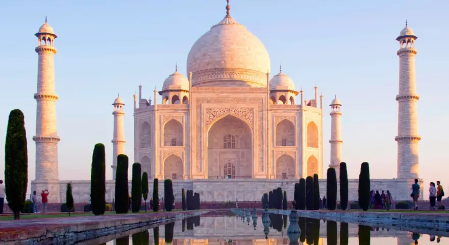 El Taj Mahal, un mausoleo de mármol blanco, se refleja en el agua. Es una maravilla arquitectónica, un símbolo de amor eterno.