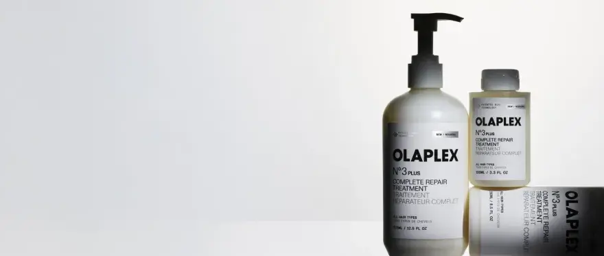 Tres botellas de Olaplex N°3, tratamiento para pelo seco o mojado, en un fondo blanco.