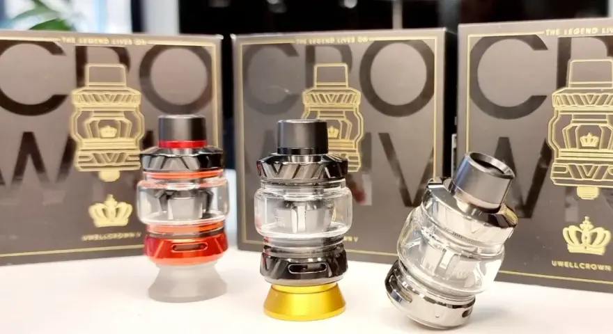 Tres atomizadores Uwell Crown V en rojo, negro y plateado, con sus cajas de fondo.
