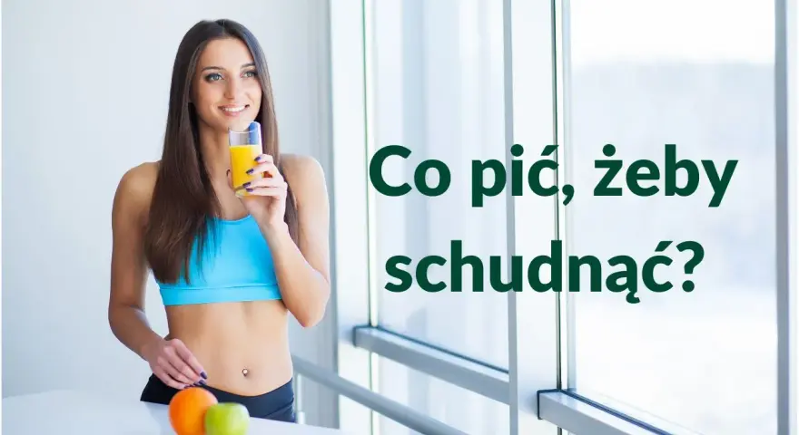 Uśmiechnięta kobieta w sportowym topie pije sok, zastanawiając się, co pić żeby schudnąć. Obok pomarańcza i jabłko.