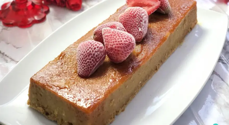 Delicioso pudin de pan casero, cubierto con fresas congeladas y un glaseado dorado.