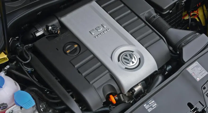Silnik Volkswagen z napisem FSI TURBO. Widoczny jest symbol marki i elementy układu dolotowego.