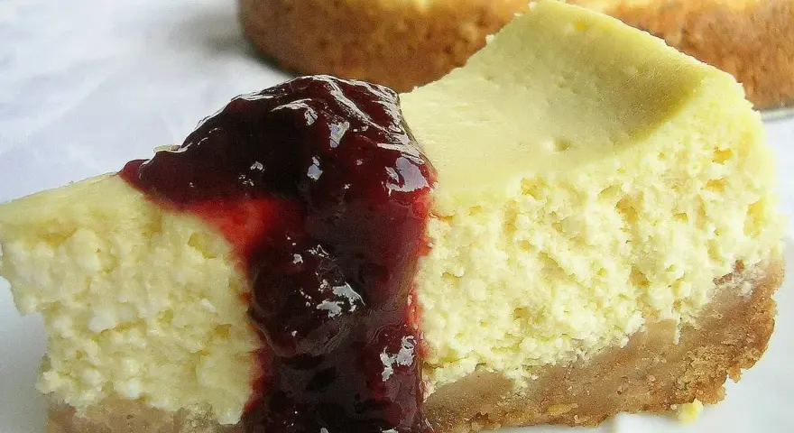 Pyszny sernik z serka wiejskiego polany wiśniową konfiturą. Idealny deser na każdą okazję.
