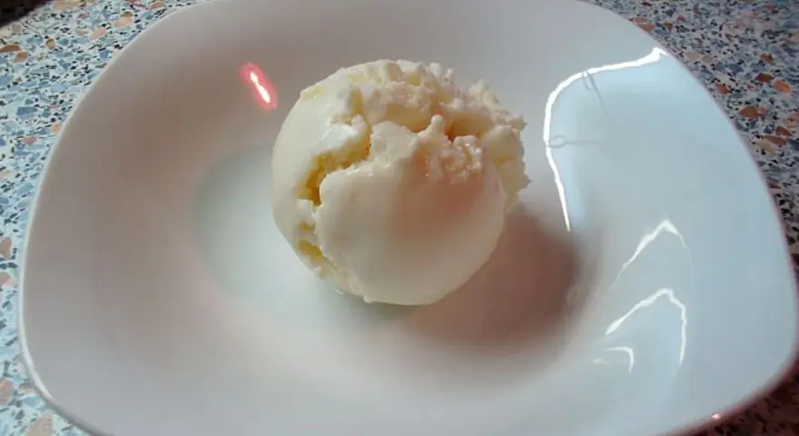 Eine Kugel cremiges Quark Eis in einer weißen Schale, bereit zum Genießen.