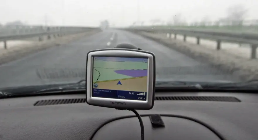 Nawigacja TomTom na desce rozdzielczej samochodu podczas jazdy w mglisty dzień.