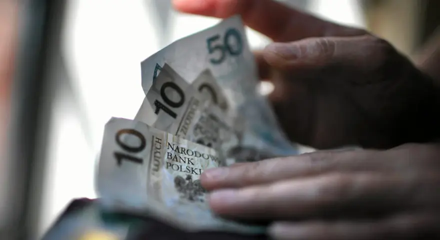 Dłonie trzymają polskie banknoty 10 i 50 zł. Czy na bierzmowanie daje się prezenty? Pieniądze mogą być odpowiedzią.