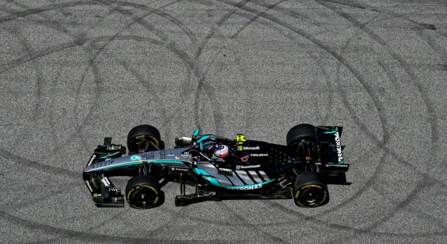 Coche de F1 Mercedes-AMG Petronas en el GP Austria, dejando marcas de neumáticos en el asfalto.