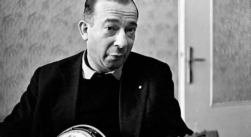 Jerzy Putrament, z gitarą w dłoniach, jakby inspirowany do tworzenia nowych utworów.