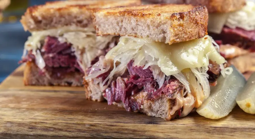 Kanapka z pastrami, kiszoną kapustą i serem. Tak wygląda pyszne pastrami co to jest, czyli wołowina w przyprawach.