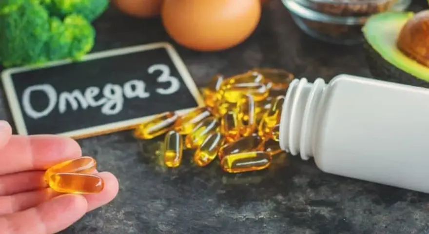 Kapsułki omega 3 na co? Na zdrowie! W tle brokuły, jajka, awokado i siemię lniane.