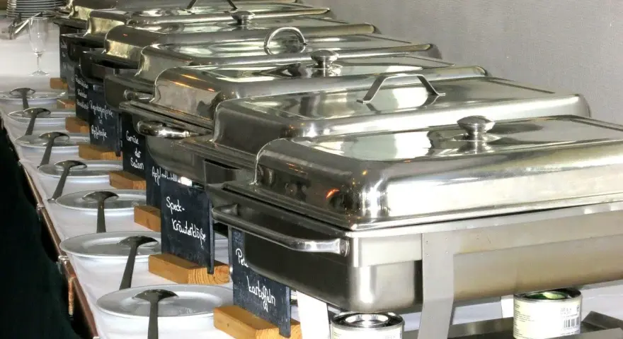 Długi rząd podgrzewaczy z jedzeniem, gotowych do serwowania. To świetny pomysł, jak otworzyć catering i zaimponować gościom.