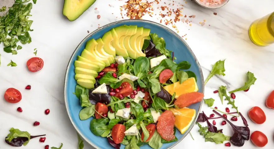Insalata di avocado fresca con pomodorini, melograno, agrumi e formaggio blu.