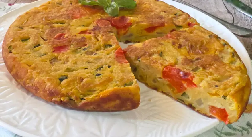 Herzhafte Frittata mit Gemüse, zubereitet in der frittata pfanne oder ofen, garniert mit Basilikum.