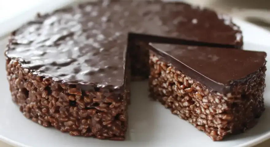 En chokladig rice crisp tårta med en bit borttagen, redo att avnjutas.